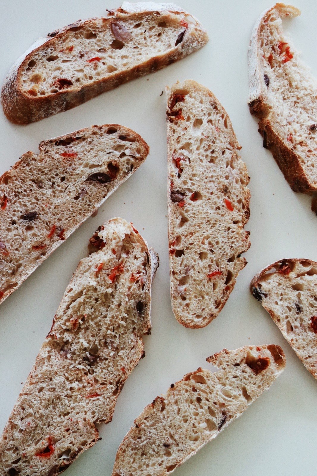 Mediterranean sourdough loaf with olives and peppers baked into the crust